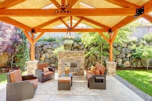 Exterior covered patio with fireplace and furniture.